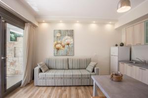 a living room with a couch and a kitchen at Kassiopea home by the sea 1 in Pefkochori