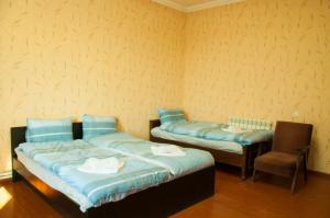 2 Betten und ein Stuhl in einem Zimmer in der Unterkunft Azhdahak B&B in Geghashen , Abovyan in Geghashen