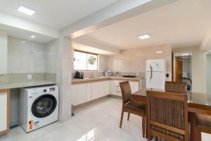a kitchen with a washing machine and a table and chairs at Residencial Oliveiras - Apartamento 3 in Brasilia
