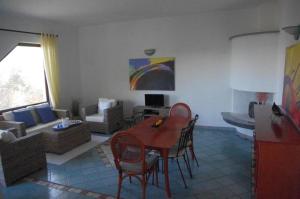 ein Wohnzimmer mit einem Tisch, Stühlen und einem Sofa in der Unterkunft Villa Maria in Cala Liberotto