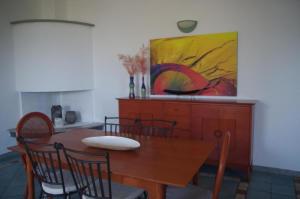 einen Esstisch mit Stühlen und ein Gemälde an der Wand in der Unterkunft Villa Maria in Cala Liberotto