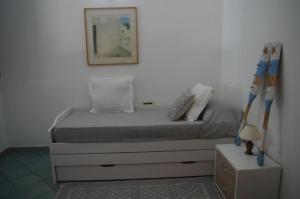 Bett in einem Zimmer mit einer weißen Wand in der Unterkunft Villa Maria in Cala Liberotto