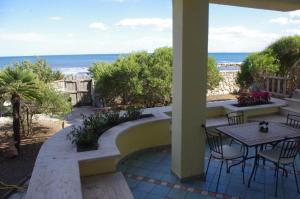 eine Terrasse mit einem Tisch, Stühlen und Meerblick in der Unterkunft Villa Maria in Cala Liberotto