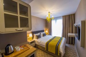 イスタンブールにあるHomelike Hotelのベッドとテレビ付きのホテルルーム