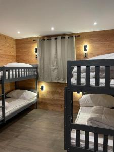 two bunk beds in a room with wooden walls at Chalet Cristal II in Les Contamines-Montjoie