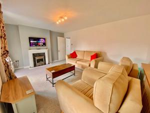 a living room with two couches and a fireplace at Leominster 3 Bedroom House, Private Parking and Garden in Leominster