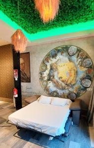 a bed in a room with a painting on the wall at LOFT DELUXE - MADRID RETIRO in Madrid