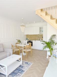 a kitchen and living room with white cabinets and a table at Domki Balticana in Władysławowo