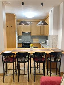 una cocina con una gran mesa de madera y sillas en Apartamento Casovall, en Esterri d'Àneu