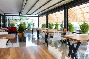 un restaurante con mesas, sillas y ventanas grandes en Akdeniz Yaşam Otel, en Silifke