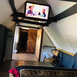 a living room with a flat screen tv on the attic at Cottonwood Barn in Goffs Oak