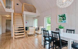 HolmsjöにあるNice Home In Holmsj With 3 Bedrooms And Wifiのリビングルーム(階段、テーブル、椅子付)