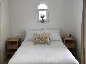 a bedroom with a bed with white sheets and a window at Modern private Suite at fantastic villa near Fuengirola in Mijas