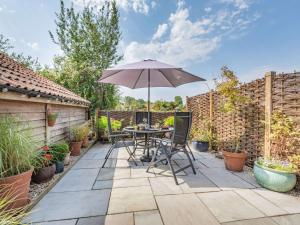 a patio with a table and an umbrella at 2 Bed in Taunton 88884 in Isle Brewers