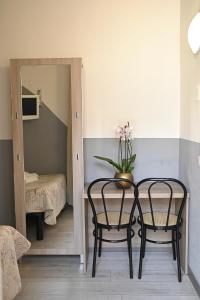 Habitación con mesa, 2 sillas y espejo. en Bovisa House B&B private rooms, en Milán