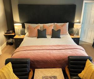 sypialnia z dużym łóżkiem z 2 krzesłami w obiekcie Elan Valley Hotel w mieście Rhayader