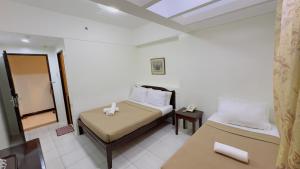 a small bedroom with a bed and a mirror at La Anclar Hotel in Davao City