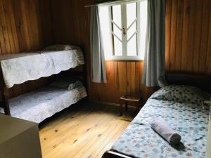 a bedroom with two bunk beds and a window at Casa Serrana in Barracão