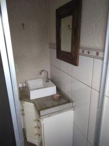a small bathroom with a sink and a mirror at Casa Serrana in Barracão