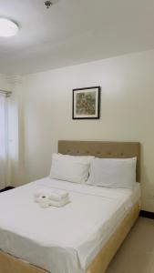 ein Schlafzimmer mit einem großen Bett mit weißer Bettwäsche in der Unterkunft La Anclar Hotel in Davao City + 70 Fotos