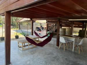a porch with two hammocks and a table and a motorcycle at Eden Farmstay CNX 