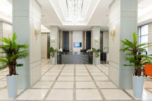 an image of an office lobby with palm trees at Park Dedeman Almaty in Almaty