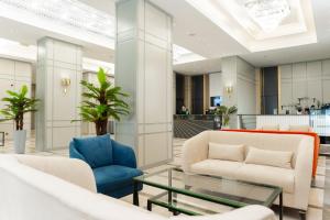 a lobby with two chairs and a glass table at Park Dedeman Almaty in Almaty