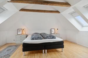 ein Schlafzimmer mit einem Bett im Dachgeschoss in der Unterkunft Come Stay 2BR Lejlighed nær Centrum & Togstation in Aalborg