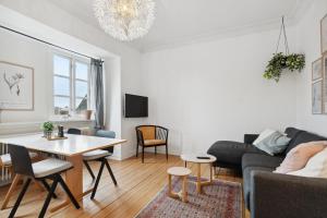 ein Wohnzimmer mit einem Sofa und einem Tisch in der Unterkunft Come Stay 2BR Lejlighed nær Centrum & Togstation in Aalborg