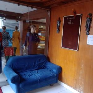 Habitación con sofá azul frente a una tienda en Hotel Cozy Residency, en Jabalpur