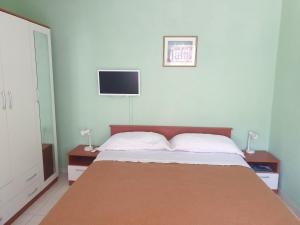 a bedroom with a large bed with two night stands at Apartments Mara in Mali Lošinj