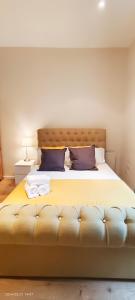 a bedroom with a large bed with two pillows at Lilac at Hammersmith in London