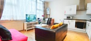 sala de estar con sofá y mesa con TV en Lilac at Hammersmith, en Londres