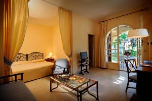 a bedroom with a bed and a table in a room at Is Morus Relais in Santa Margherita di Pula