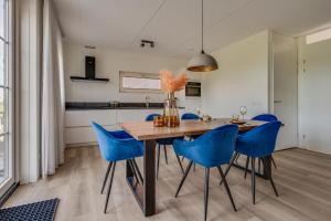 comedor con mesa de madera y sillas azules en HUB Resorts Knuitershoek, 