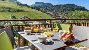 a table with a bowl of bread and glasses of orange juice at Les Congères in Le Grand-Bornand