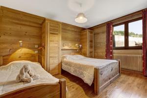 1 dormitorio con 2 camas y un osito de peluche en la cama en Les Congères, en Le Grand-Bornand