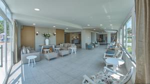 a lobby of a hospital with chairs and tables at Hotel Sarti Beach in Sarti