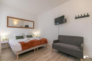 um quarto com uma cama, uma cadeira e um espelho em MBA - Splendide Appart - Bobillot - Proche Vincennes em Montreuil