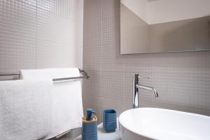 een badkamer met een wastafel, een toilet en een spiegel bij Canova apartment in Noto