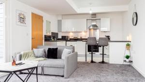 a living room with a couch and a kitchen at Stunning flat near the Lake in Gosport