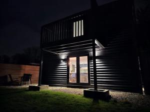 a black house with a window at night at Relaxation & Romance in Manston