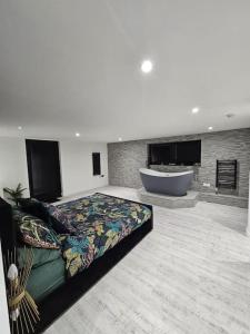 a large room with a bed and a bath tub at Relaxation & Romance in Manston