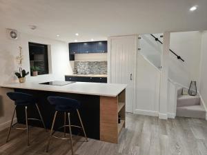 a kitchen with a counter and two bar stools at Relaxation & Romance in Manston