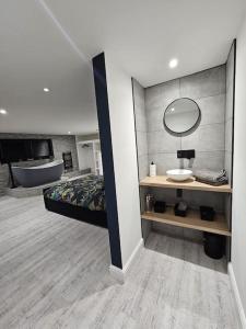 uma casa de banho com uma cama, um lavatório e um espelho. em Relaxation & Romance em Manston