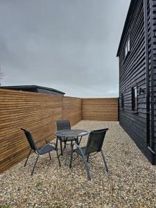 un patio con una mesa y 2 sillas y una valla en Relaxation & Romance en Manston