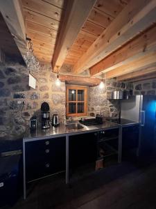 uma cozinha com um lavatório e uma bancada em Buron Cœur d’Aubrac em Marchastel