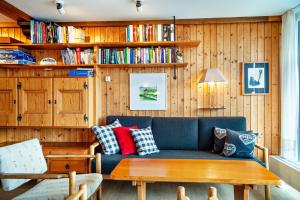 a living room with a blue couch and wooden walls at Ferienhaus Rommel in Stiefenhofen