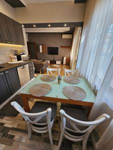 a kitchen with a table and chairs in a kitchen at Grey central apartment in Varna City