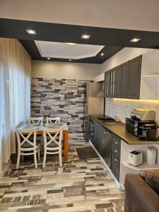 uma cozinha com mesa e cadeiras num quarto em Grey central apartment em Varna City